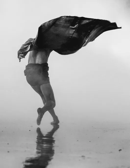 Dancer reflected on wet sand